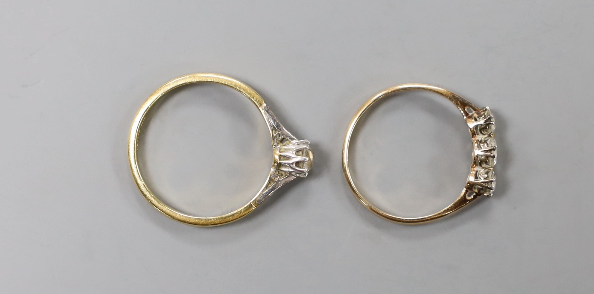 An 18ct and plat. single stone diamond ring, with diamond set shoulders, size O/P and a yellow metal and three stone diamond ring, size M, gross weight 3.8 grams.